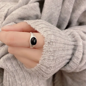 Matte silver ring with oval black agate gemstone shown on hand for a minimalist retro look