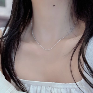Close-up of a minimalist S925 sterling silver geometric block necklace worn on a woman's neck