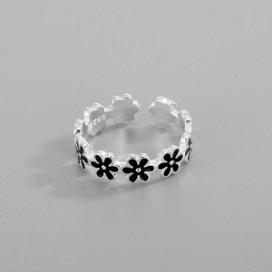 Macro view of S925 sterling silver ring featuring black enamel flower petals and engraving
