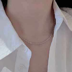 Close-up of a delicate S925 sterling silver geometric necklace worn on the collarbone