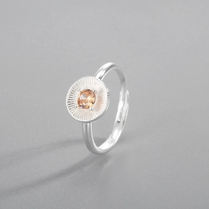 Detailed macro of S925 silver ring featuring sunburst texture and orange zircon