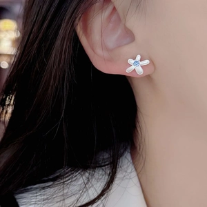 Elegant S925 sterling silver flower stud earrings with blue zircon center on model