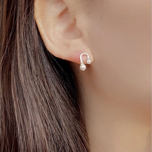 Elegant 925 sterling silver U-shaped earrings with dual white pearls on a model ear