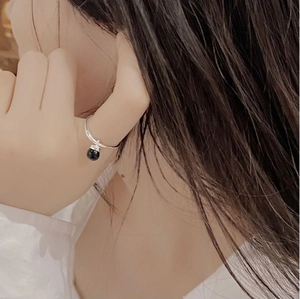 Detailed view of an S925 silver ring featuring a black agate bead charm on a finger