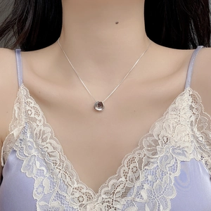 Minimalist S925 sterling silver skirt-shaped necklace on model with lavender lace top
