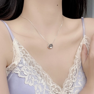 Close-up of S925 sterling silver necklace with bean pendant on woman neck