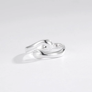 Vue macro détaillée du design mains enlacées en argent poli sur la bague
