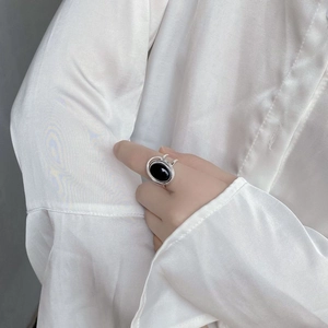 Detail of 925 sterling silver ring featuring a large oval black onyx stone on a model hand
