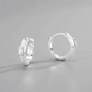 Detail of S925 sterling silver huggie earrings with white enamel and rectangular zircon