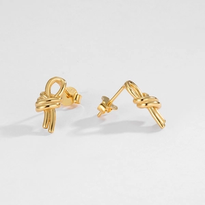 Close-up of S925 sterling silver hallmark on gold knot earrings with minimalist metal design