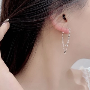 Detail view of shimmering S925 sterling silver multi-layer tassel earrings on a model