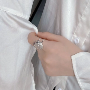 Detailed view of silver double-layered ring with oval white chalcedony on model hand