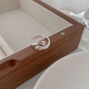 Bague câlin minimaliste en argent S925 sur une boîte à bijoux en bois poli