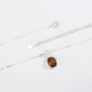 Macro view of S925 sterling silver necklace with oval tiger eye stone pendant