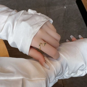 Détail d'une bague mains enlaçantes en argent S925 doré ajustable portée au doigt