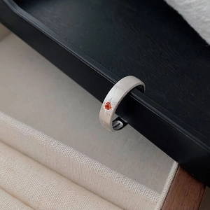 Close-up of brushed S925 silver ring with starburst engraving and orange gemstone