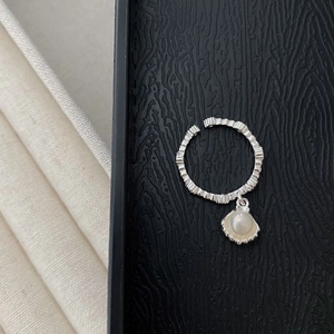 Detailed shot of S925 silver shell ring with natural pearl and textured band detail