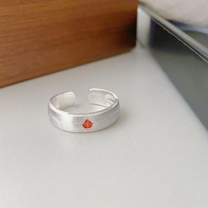 Macro detail of S925 sterling silver brushed ring with orange gemstone and hallmark
