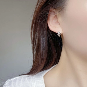 Macro shot of S925 sterling silver heart earrings with black enamel bow detail