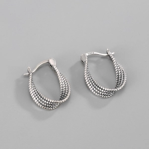 Macro shot of S925 sterling silver stamp on minimalist twisted hoop earrings
