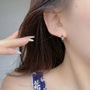 Close-up of S925 sterling silver hoop earrings with black and clear enamel inlay details