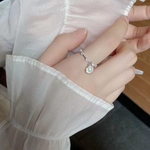 Macro detail of S925 silver shell ring with natural pearl and zircon accents on a finger