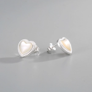Macro shot of S925 silver heart stud earrings with white mother of pearl and rope edge