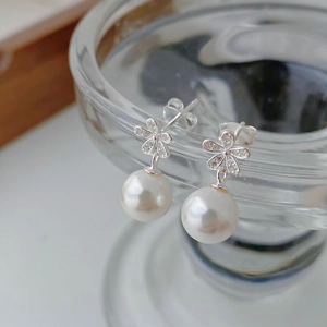 Detailed macro view of S925 sterling silver flower earrings with small diamonds and white pearls