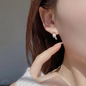 Close-up of S925 sterling silver knotted earrings worn on ear in minimalist design