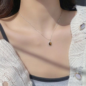 French vintage S925 silver necklace with oval tiger eye stone pendant on white knit sweater
