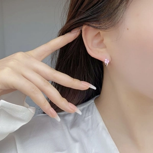 Gros plan d'une boucle d'oreille S925 en argent avec zircon carré rose sur mannequin