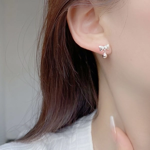 Delicate S925 sterling silver bow stud earrings with small round beads on model
