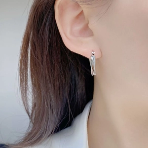 Macro detail of S925 sterling silver twisted rope hoop earrings worn on female ear