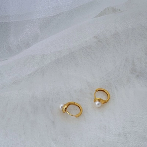Elegant 925 silver gold hoop earrings with natural freshwater pearls on white fabric
