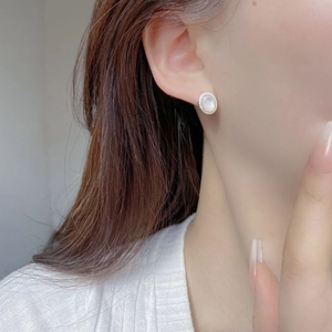 Détail de la boucle d'oreille en argent S925 avec bord torsadé et nacre blanche