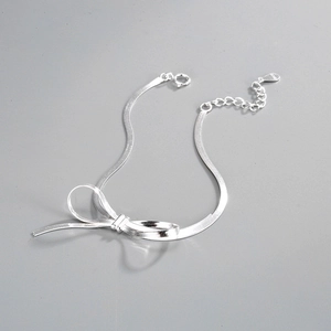 Detail showing the S925 hallmark on a silver bow necklace with elegant snake chain links