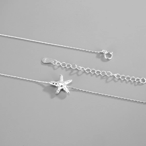 Macro detail of S925 sterling silver starfish pendant showing realistic texture and hallmark