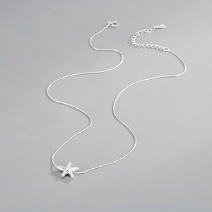 Macro detail of S925 sterling silver starfish pendant with textured lava finish and clasp