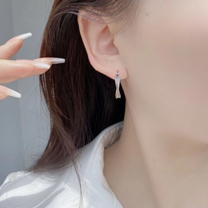 Minimalist S925 sterling silver twisted hoop earrings worn by a model in a side profile view