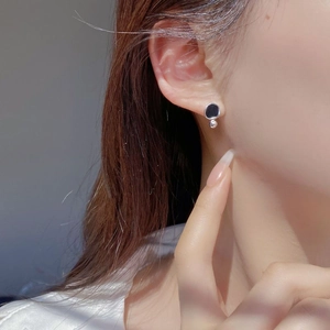 Close-up of French vintage S925 silver irregular black enamel stud with silver bead pendant
