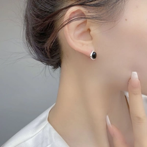 Primo piano dell'orecchino in argento S925 con onice nera indossato da una modella