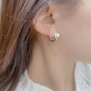 Detail of minimalist 925 silver earring with natural freshwater pearl on ear