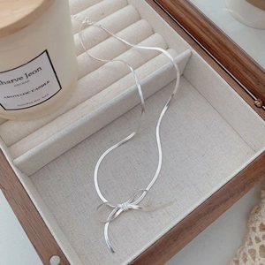 S925 sterling silver blade chain necklace with a textured bow pendant in a jewelry box