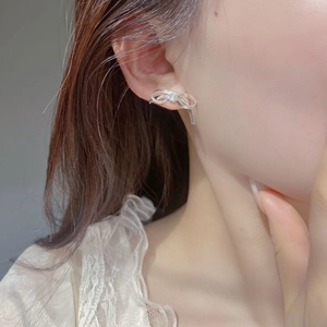 Elegant 925 sterling silver bow knot stud earrings worn by a model in a minimalist style