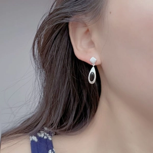 Close-up of model wearing S925 silver water drop earrings with black agate inlays