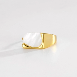 Close-up of a minimalist gold ring featuring an irregular white mother of pearl inlay