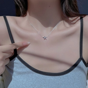 Close-up of S925 sterling silver starfish necklace with molten texture on female model