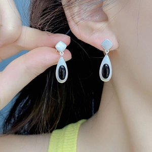Detail of matte S925 silver teardrop earrings with black agate stone in close-up view