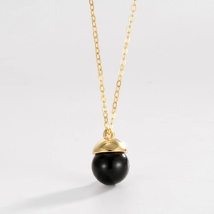 Macro detail of black agate orb pendant with gold cap on minimalist S925 silver chain