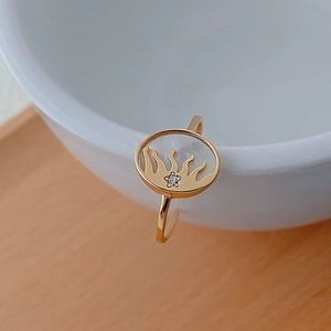 Détail de la bague d'oreille dorée avec nacre blanche et cristal étoile étincelant